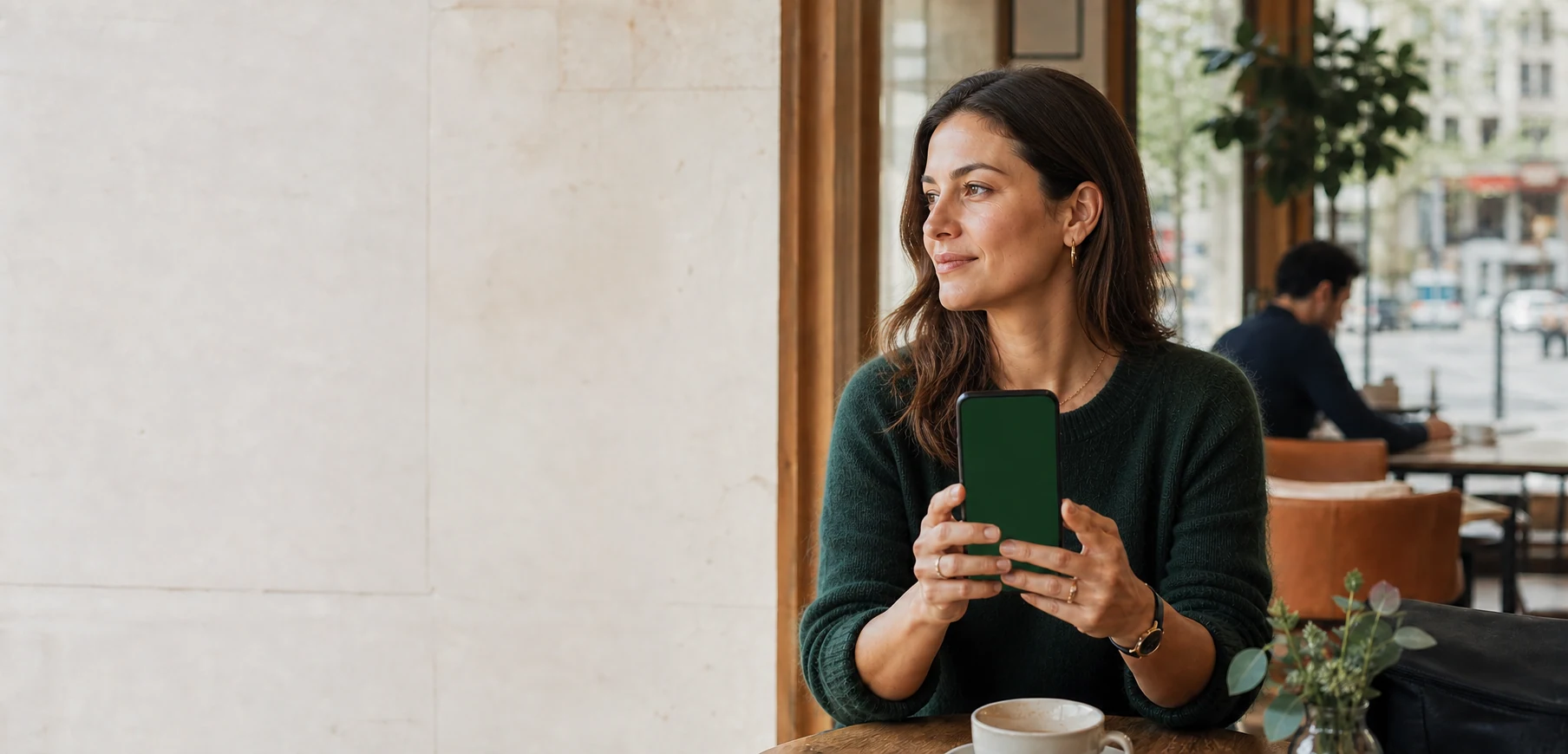 A woman holding her phone during a quiet morning at a neighborhood café